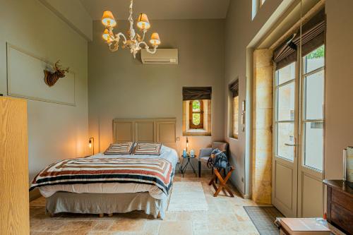 a bedroom with a bed and a chandelier at Clos Marcamps - Teritoria in Prignac-et-Marcamps