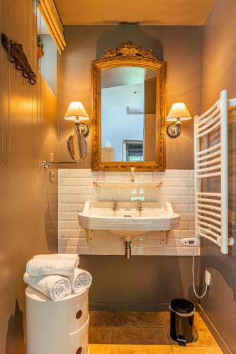 a bathroom with a sink and a mirror at Clos Marcamps - Teritoria in Prignac-et-Marcamps