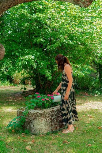 a woman standing next to a planter with flowers at Clos Marcamps - Teritoria in Prignac-et-Marcamps