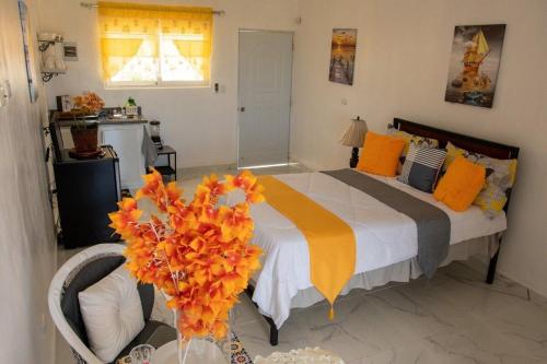 1 dormitorio con 1 cama y un jarrón de flores en Royal Terrace Princess II, en San Felipe de Puerto Plata