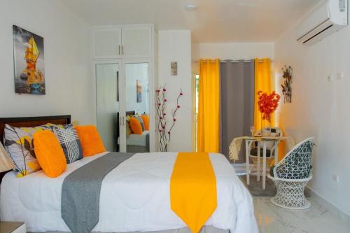 a bedroom with a bed with orange and gray pillows at Royal Terrace Apto. II (Princess) in San Felipe de Puerto Plata