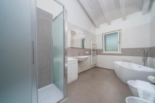 uma casa de banho com um chuveiro, uma banheira e um lavatório. em The House of Antonietta em Udine