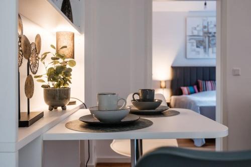 a white table with two cups and plates on it at Refugium mit Stil I Nähe HBF und Innenstadt in Hannover