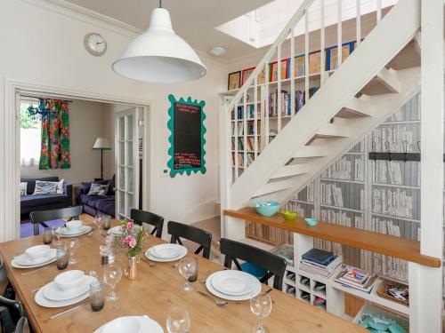een eetkamer met een tafel en stoelen en een trap bij Pass the Keys Luxury City Centre House in Bath
