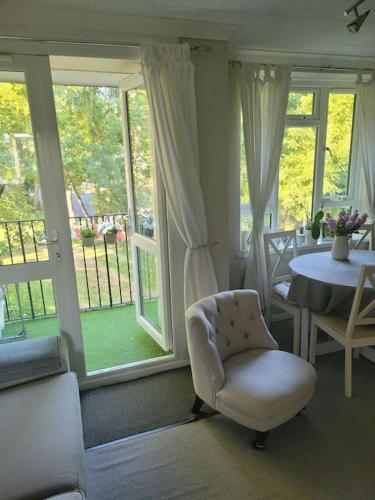 倫敦的住宿－Comfortable two bedroom flat in Putney.，客厅配有椅子、桌子和窗户