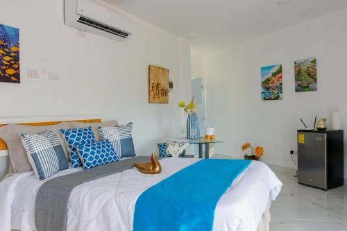 a bedroom with a large bed with blue and white pillows at Royal Terrace IV (King) in San Felipe de Puerto Plata