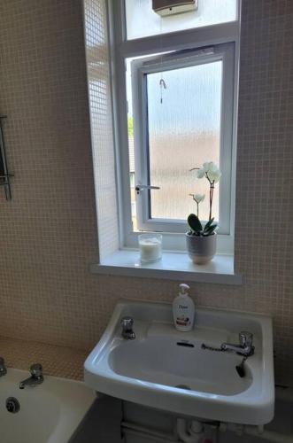 a bathroom with a sink and a window at Comfortable two bedroom flat in Putney. in London