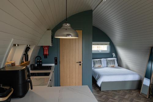 een kleine slaapkamer met een bed en een keuken bij Glengolly Getaways in Thurso
