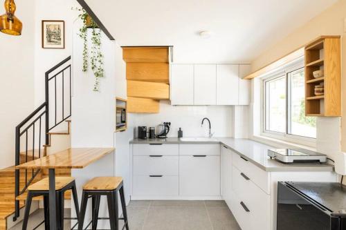 uma cozinha com armários brancos e uma mesa de madeira em Earth & Heavens em Kinneret