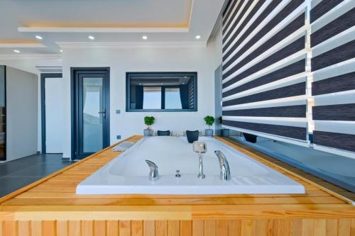 a bathroom with a bath tub with two faucets at Hadi Villa in Kalkan