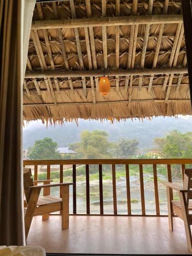 a room with a table and chairs on a balcony at Jack Ecolodge in Lung Co (1)