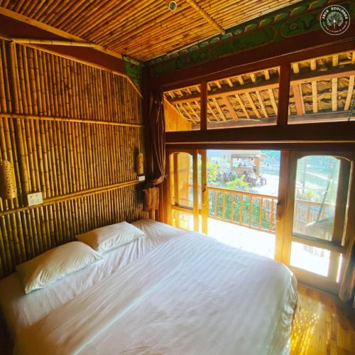 a bedroom with a bed and a large window at Jack Ecolodge in Lung Co (1)