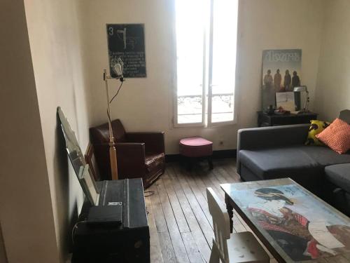 a living room with a couch and a table at Porte de Paris - Saint-Denis quartier historique in Saint-Denis