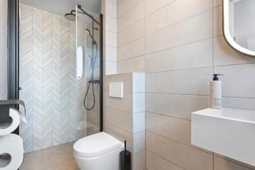uma casa de banho branca com um WC e um chuveiro em Dutch Design Hotel Vondelpark em Amsterdã