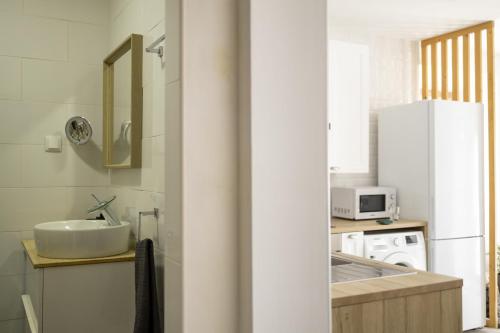 uma cozinha com um lavatório e um frigorífico branco em Seixal Bay Apartments em Arrentela