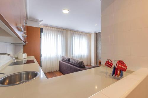 una cocina con fregadero y un sofá en una habitación en Apartamentos Verdemar (VUT), en Llanes