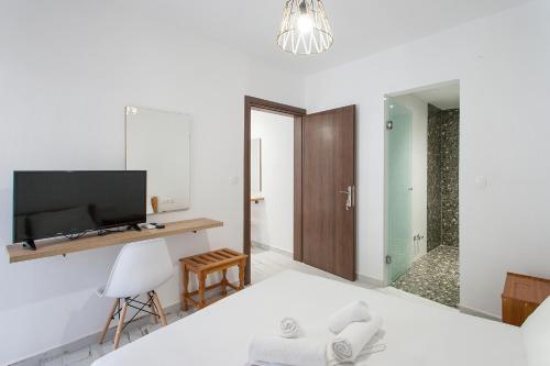 a bedroom with a bed and a tv and a mirror at ELIZA Skiathos in Skiathos Town