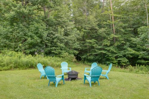 a group of blue chairs sitting in the grass at Otego Home with Hot Tub Near All Star Village! in Oneonta