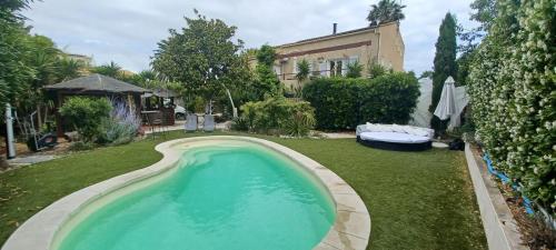 uma piscina no quintal de uma casa em Chambre d hôte avec piscine em Agde