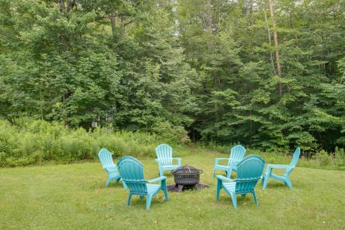 a group of blue chairs sitting around a fire pit at Otego Home with Hot Tub Near All Star Village! in Oneonta
