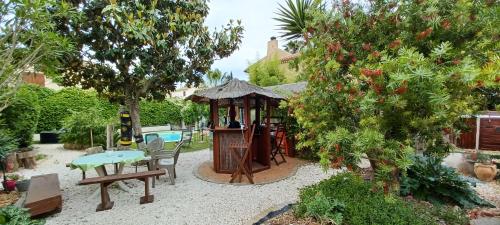 - un jardin avec un kiosque, une table et un banc dans l'établissement Chambre d hôte avec piscine, à Agde