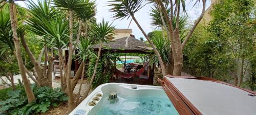 una bañera en un patio con palmeras en Chambre d hôte avec piscine, en Agde