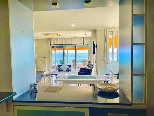 ein Wohnzimmer mit einem Tisch und Meerblick in der Unterkunft Golden Coast Panagias Apartment in Volos