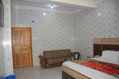 a bedroom with a bed and a chair and a door at Eagle Nest, Malam Jabba by LMC in Swat