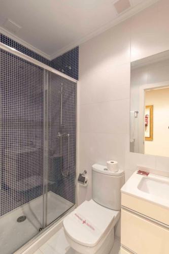 a bathroom with a toilet and a shower and a sink at Apartamentos Verdemar (VUT) in Llanes