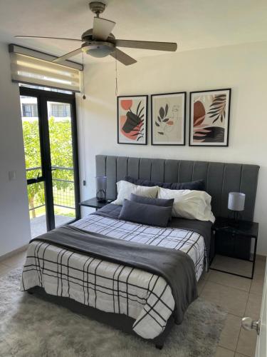 a bedroom with a large bed with a ceiling fan at Bambú Residencial 2 Recámaras, Alberca, Seguridad 24hrs in Puerto Vallarta