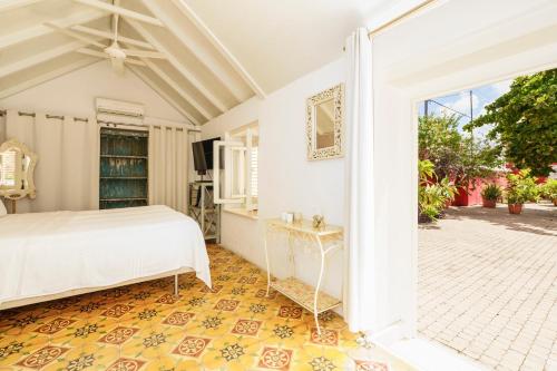 a bedroom with a bed and an open door at Villa Tokara Boutique Hotel in Willemstad