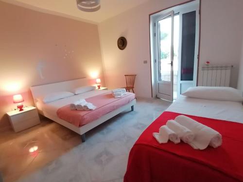 a bedroom with two beds with red and white sheets at Mary Rose ideale per 2 famiglie o gruppi di amici in Spongano