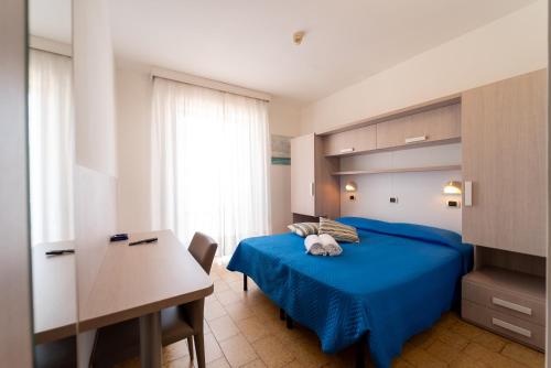 a bedroom with a blue bed and a desk at Hotel Beach in Tortoreto Lido