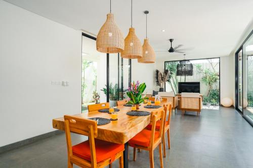 a dining room with a large wooden table and chairs at Villa Bunga Lily - Sumptuous 3BR Luxury Private Villa in Canggu in Canggu