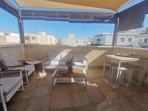 a balcony with white furniture and a view of the city at Botavara in El Cabo de Gata