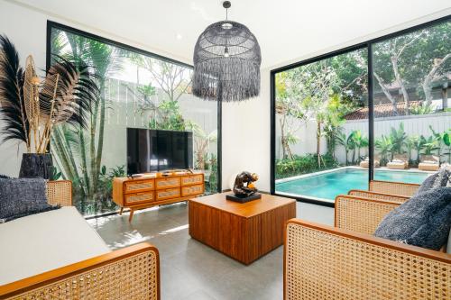 a living room with a tv and a pool at Villa Bunga Lily - Sumptuous 3BR Luxury Private Villa in Canggu in Canggu