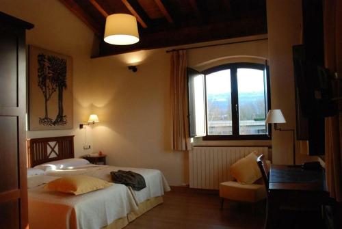a hotel room with two beds and a window at OLATZEA LANDA HOTELA in Arbizu