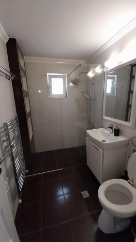 een badkamer met een wit toilet en een wastafel bij EBI Apartment in Cluj-Napoca
