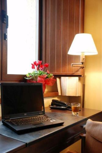 a laptop computer sitting on a desk with a lamp at OLATZEA LANDA HOTELA in Arbizu