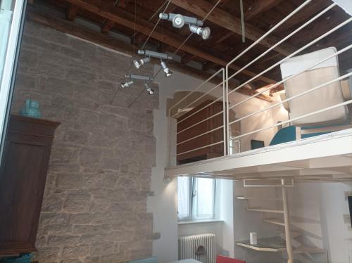 a loft bed in a room with a brick wall at Casa Vacanze Il Geco in Trani