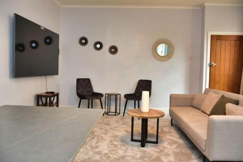 a living room with a couch and black chairs at Crondall Stores Flat in Crondall