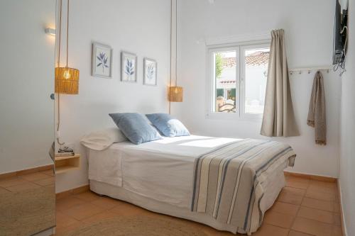 a bedroom with a bed and a window at Casa Menorquina centro Ciutadella in Ciutadella