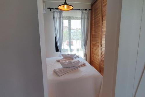 Schlafzimmer mit einem Bett mit weißer Bettwäsche und einem Fenster in der Unterkunft Peacefull Casa Donja Lastva in Tivat