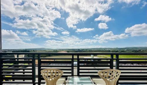 a balcony with two chairs and a table and a view at Sun Shine B&B in Hengchun