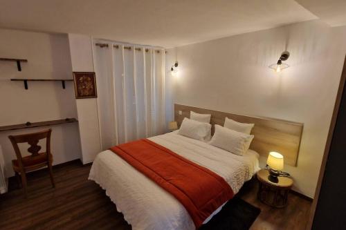 een slaapkamer met een bed met een oranje en witte deken bij Le Cygne in Château-Thierry