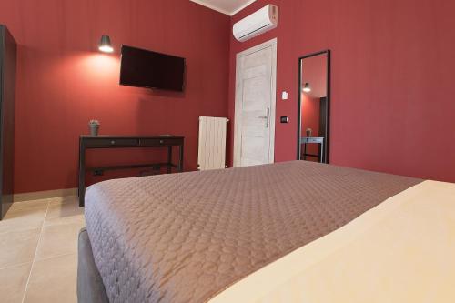 a bedroom with a bed and a tv on the wall at Malù - Bed & Breakfast in Agrigento