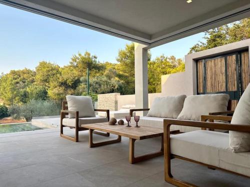 a living room with a couch and a table at Milva by Goutos Luxury Living in Agios Aimillianos