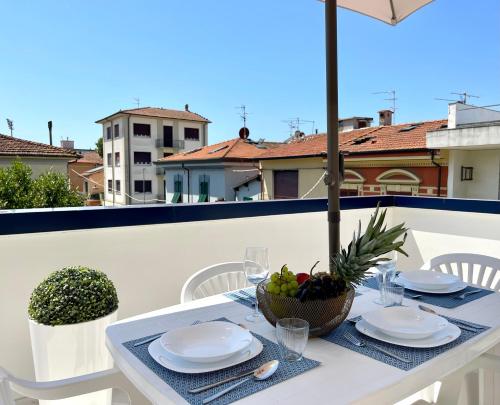 a white table with a bowl of fruit on a balcony at Darsena Luxury apartments in Viareggio