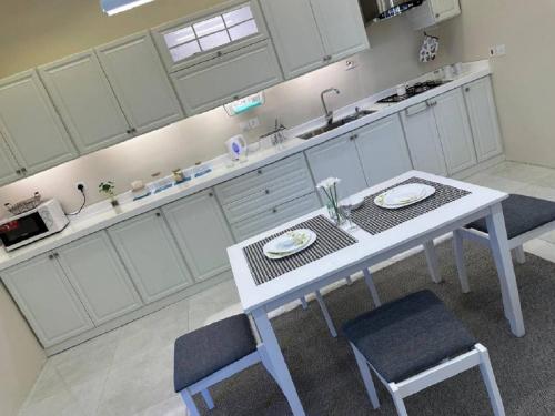 a white kitchen with a table and two chairs at ذكريات الصيف in Taif