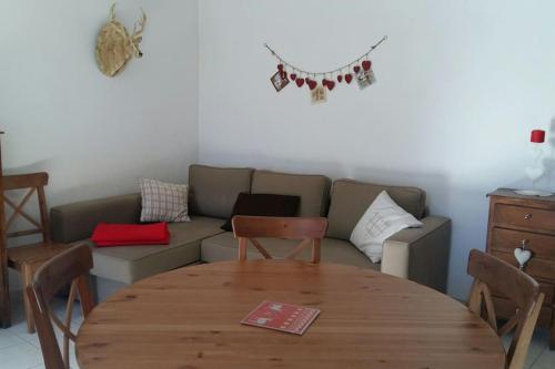 a living room with a couch and a wooden table at Appartement chalet 4 pers 45m2 Puy Saint Vincent in Puy-Saint-Vincent